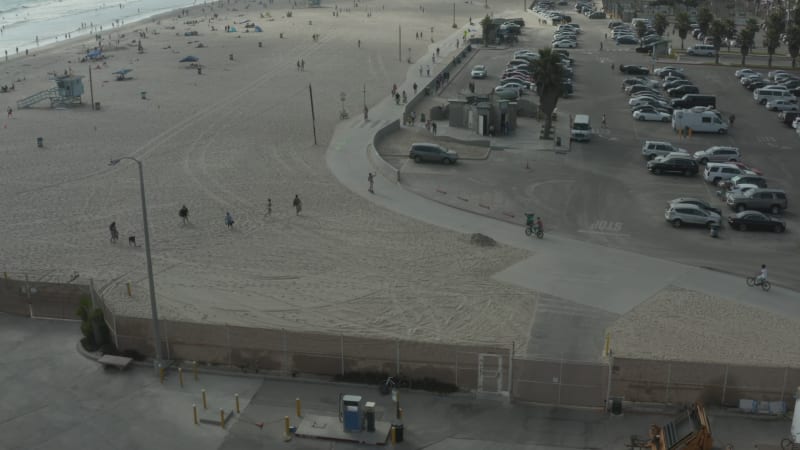 Circling around Venice Beach skatepark and boardwalk with palm trees and bike lane, Sunny, Los Angeles California