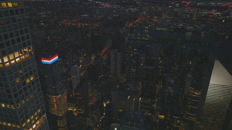 Fly around modern tall apartment building. Revealing panoramic view of night city. Queensboro Bridge and Queens district. Manhattan, New York City, USA