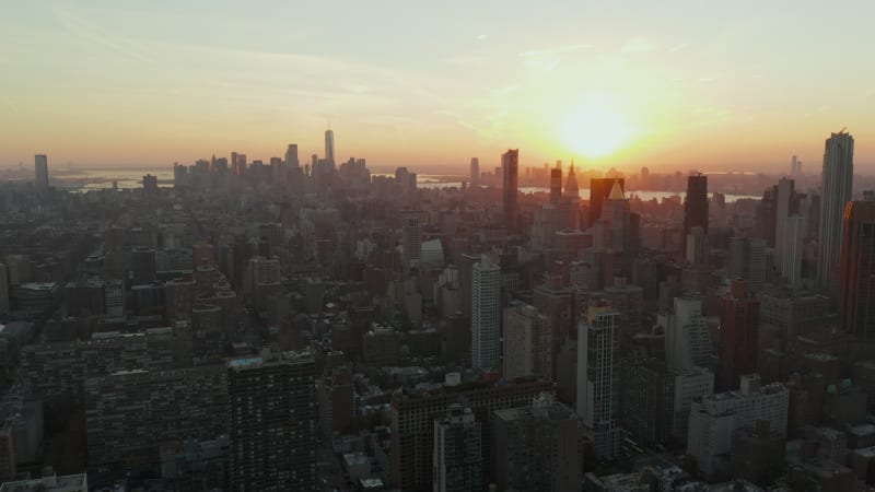 Aerial panoramic footage of city at dusk. Downtown skyscrapers in distance. View against colourful sunset sky. Manhattan, New York City, USA