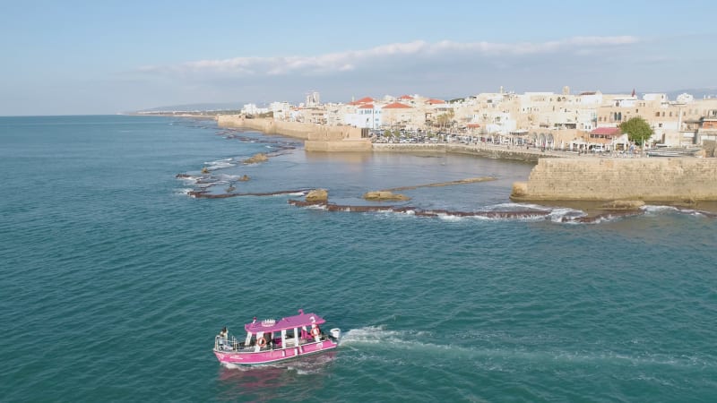 Aerial view of a passenger boat sailing near Acre old town, Israel.