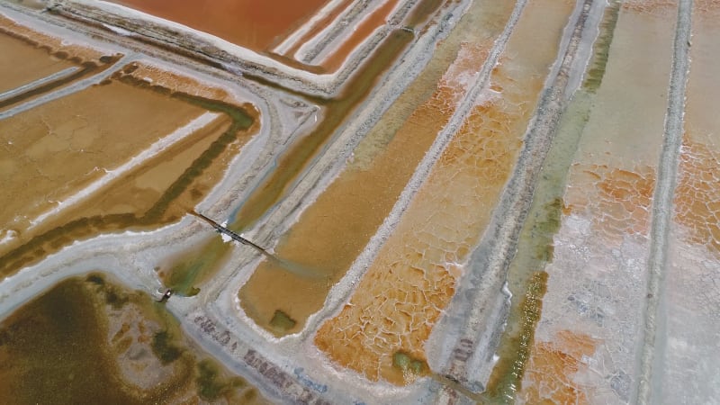 Aerial view above of big salt industry near a coastal village.