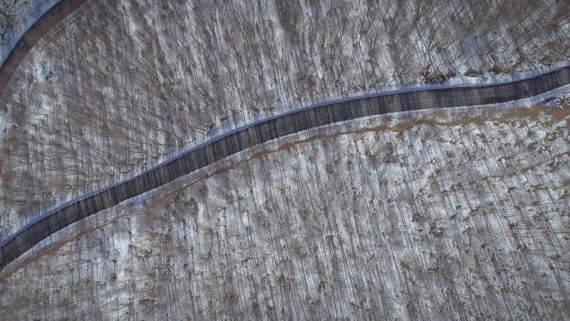 Aerial view of a winding road in the snowy hills of Greece.