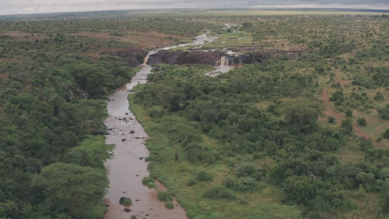 Wide aerial view of rocky river waterfall in wild African landscape