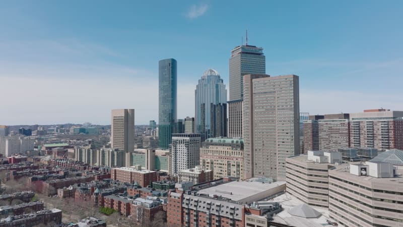 Group of high rise buildings, office towers and hotel. Glossy glass facade reflecting surrounding buildings. Sunny day in metropolis. Boston, USA