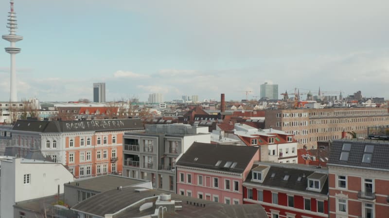 Ascending aerial view of houses in residential neighborhood near radio telecommunication tower in Hamburg