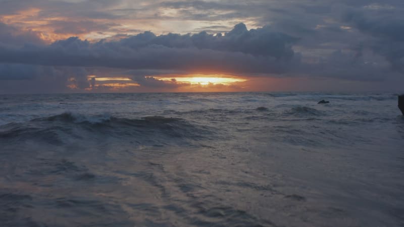 Close up view of blue sea waves in twilight. Rough ocean waves in stunning golden sunset light