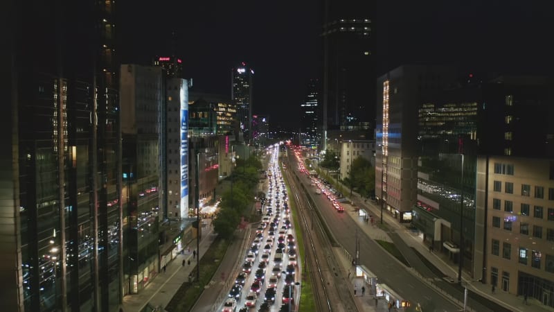 Ascending footage of traffic jam in multilane road. Long standing queue of cars leading through nigh city. Warsaw, Poland