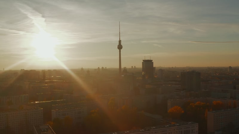 Low flight above Berlin, Germany residential neighbourhood street and rooftops towards City center with TV Tower Skyline, Scenic Autumn vibe Aerial Dolly in