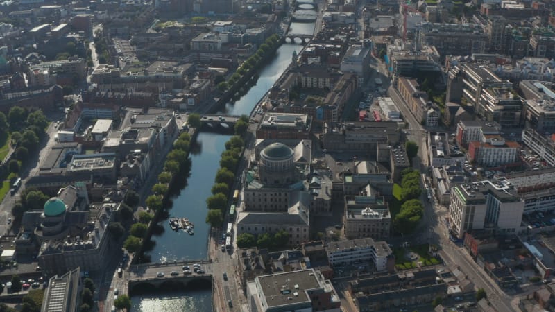 Aerial view of historic buildings with domes on riverbanks. Traffic on bridges across Liffey river. Dublin, Ireland