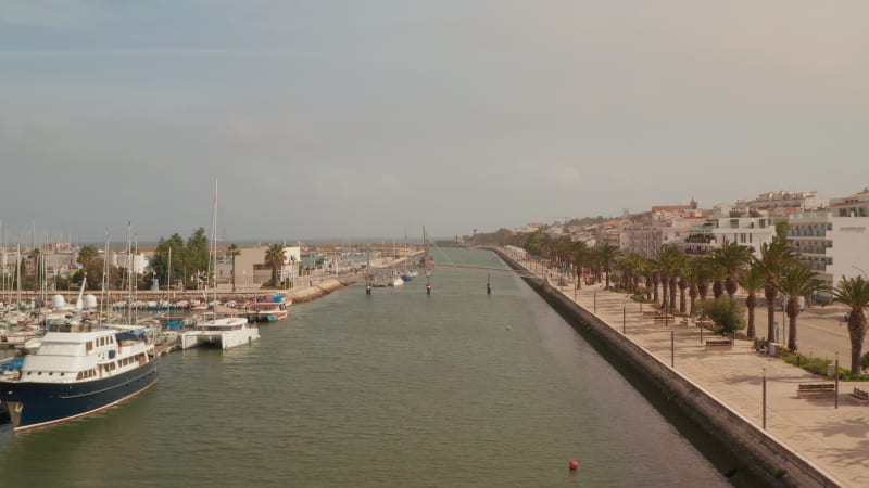 Lagos port, drone flying forward above main canal, Portugal, aerial view above seafront, sunny day