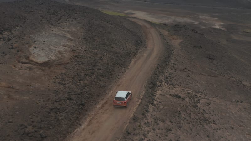 Drone view car driving off road terrain exploring wilderness of Iceland. Birds eye 4x4 jeep discovering surreal icelandic highlands, expedition in scandinavian extreme landscape