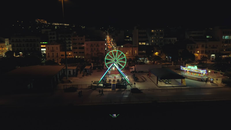 Aerial view of small amusement park with lights at night.