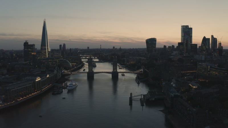 Aerial view of ferry crossing thames river during sunset.