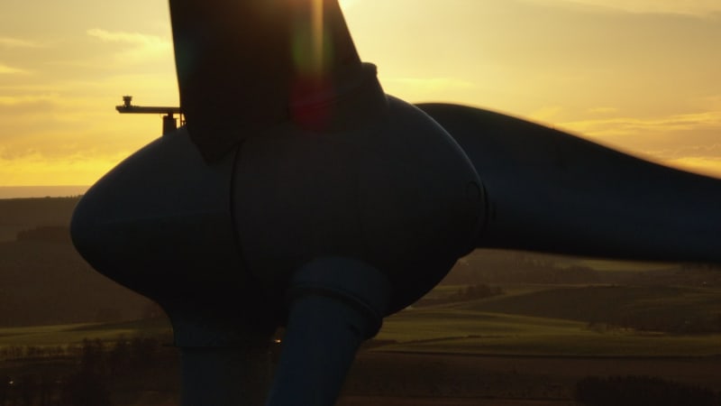 Wind Turbine Silhouette at Sunset Generating Renewable Energy