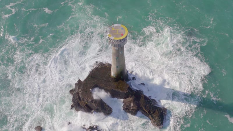 Lighthouse on a Rock in the Ocean with Crashing Waves and a Helipad