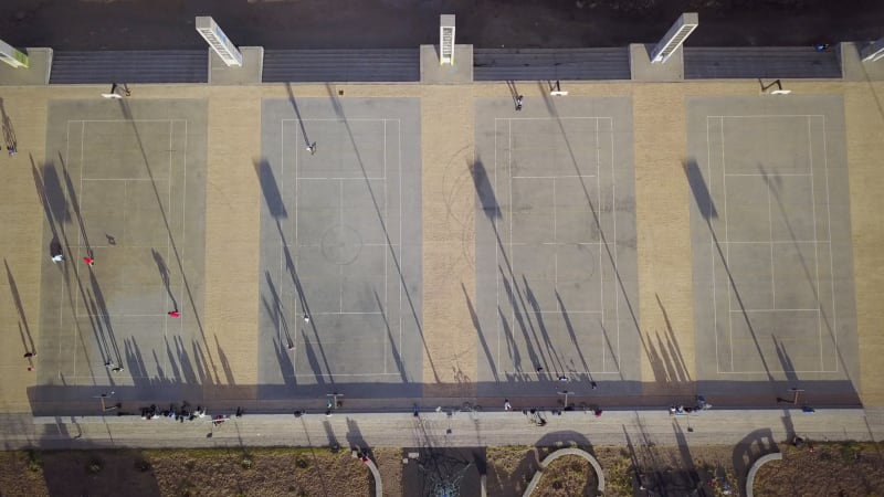 Aerial view of four basketball courts in an urban setting.