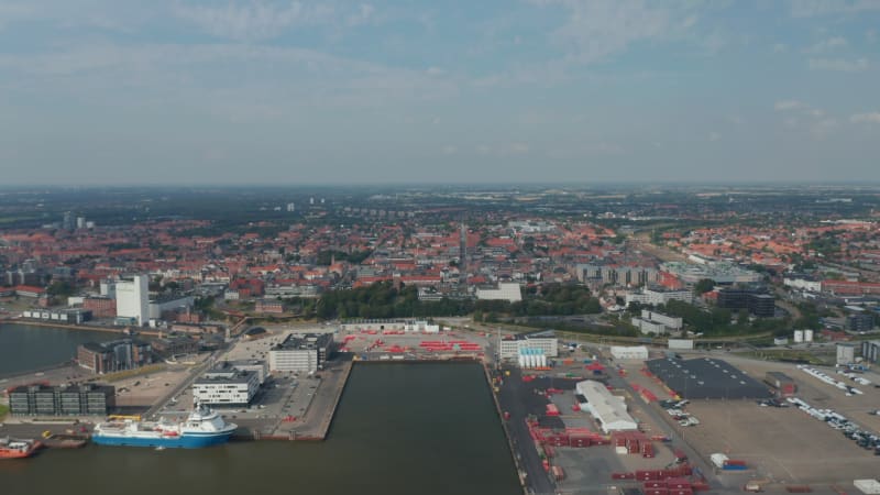 Flight forward over the seaport of Esbjerg, the most important of Denmark and North Sea. Aerial view showing a beautiful panorama of the city build with characteristic red brick