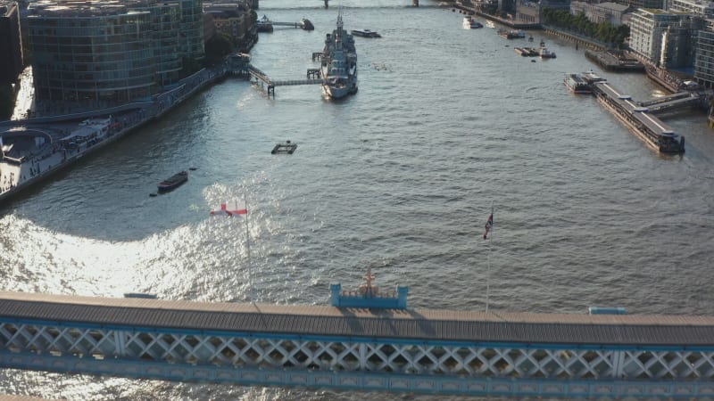 Fly over top walkway of Tower Bridge. Tilt up reveal of bridges across River Thames and cityscape. London, UK