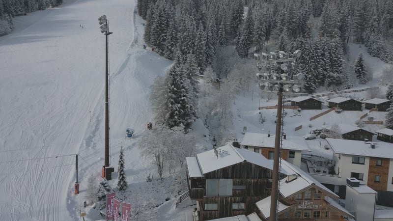 Aerial reveal shot of a light poles at a Ski Slope and Mountain View in Flachau, Austria