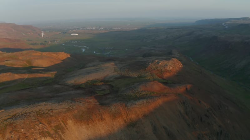 Amazing aerial view golden light highlands smooth orange rhyolite formations in Iceland. Drone view spectacular landscape with steaming fumaroles and cliffs covered by moss