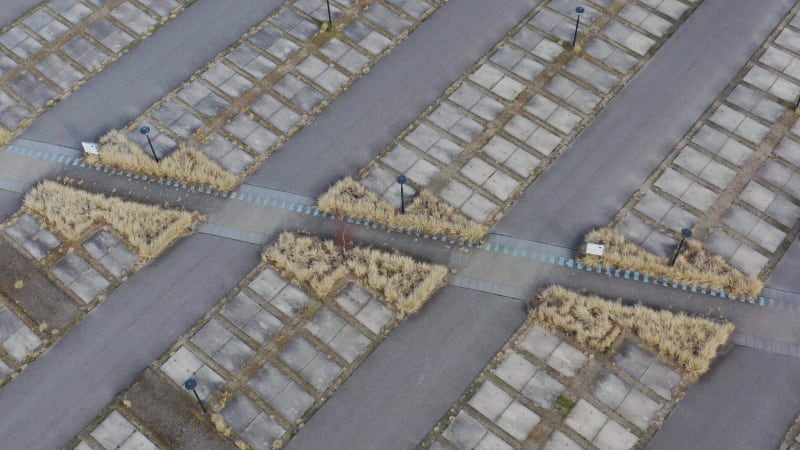 Abstract aerial pullback shot above an empty car parking lot.