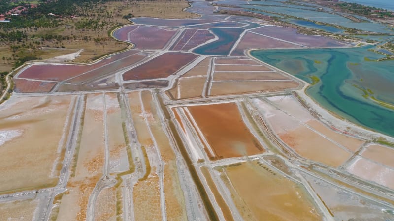 Aerial view of big salt industry near a coastal village.