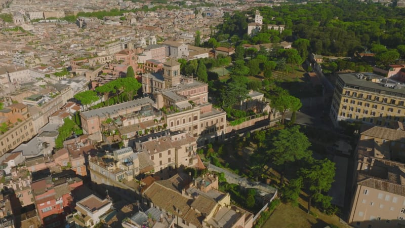 Aerial view of historic buildings in old city. Houses, landmarks and surrounding park with green trees. Rome, Italy