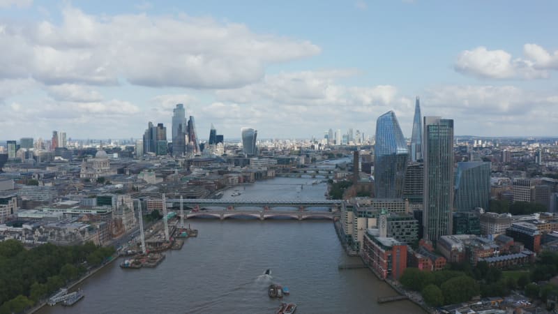 Aerial view of large modern city with tall skyscrapers. Fly above River Thames, Blackfriars Bridge Foreshore construction site at bank. London, UK