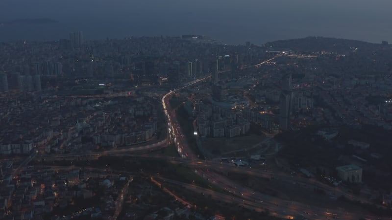 Wide Aerial View over Istanbul New Financial District at Dusk with Freeway traffic, tilt down