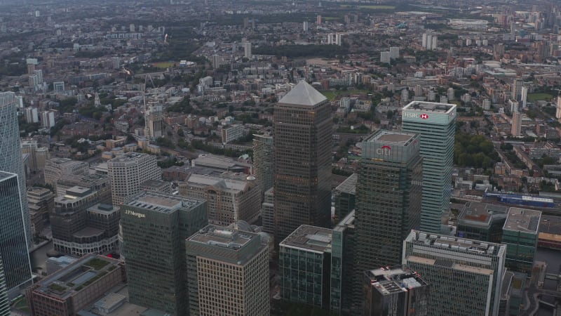 Aerial view of tall modern building around Canada Square in Canary Wharf business district. Canada, HSBC, Citi and other office skyscrapers after sunset. London, UK