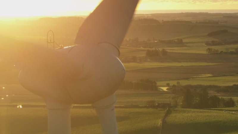 Wind Turbine Silhouette at Sunset Generating Renewable Energy