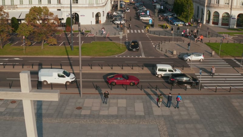 Side view of cars stopping and giving way to pedestrians on crosswalk in city. Traffic in streets of town. Warsaw, Poland