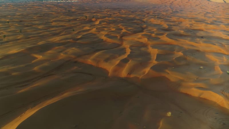 Aerial view of dunes creating shadows at a desert landscape.