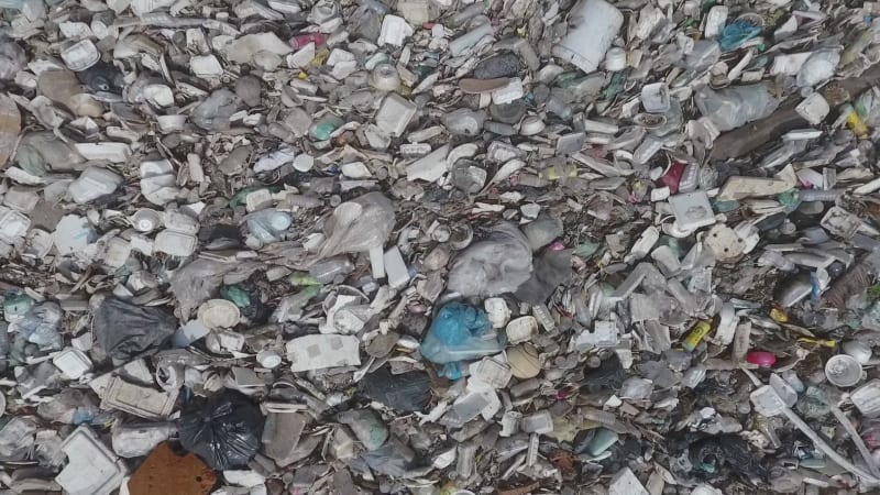 Aerial view of trash floating on a river.