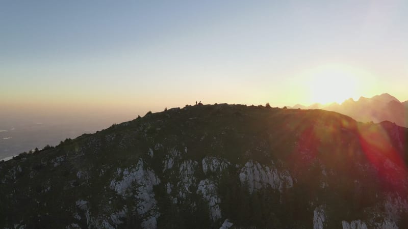 Aerial view of campers on mountain peak during sunrise