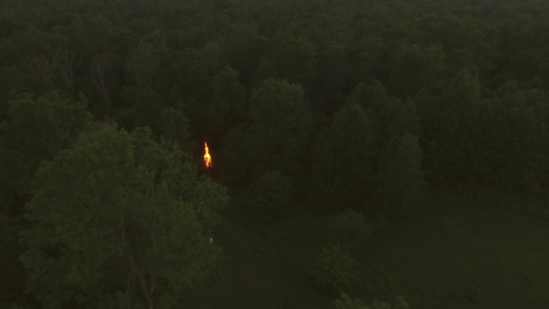 Aerial view of a campfire in the forest at sunset.