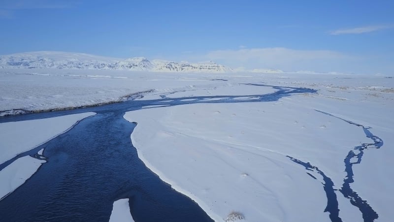 Aerial View of a Blue River in a Snowy Landscape