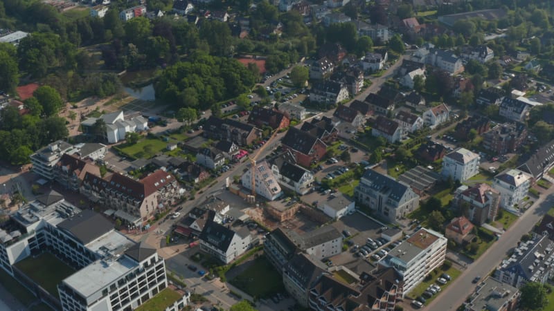 High aerial view of residential area houses in Scharbeutz, Germany, forward, tilt up reveal amazing countryside landscape, day