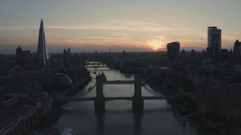 Aerial view of bridge crossing thames river during sunset.