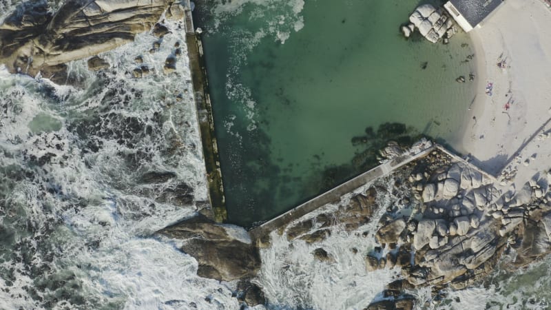 Above man-made ocean pool with crashing ocean waves beyond