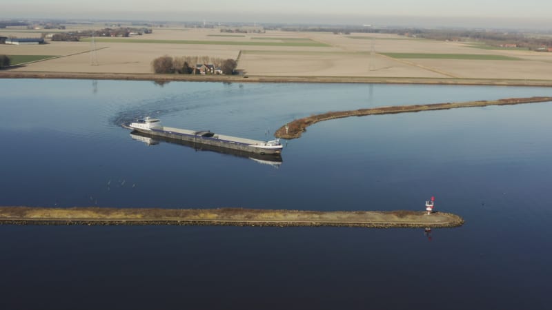 Cargo ship slowly navigating river turn