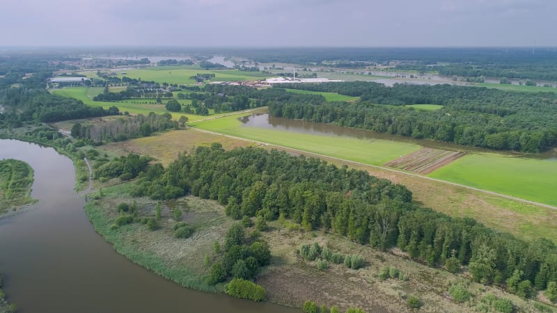 Aerial view of flooded floodplains of river Maas with trees, Megen, Netherlands.