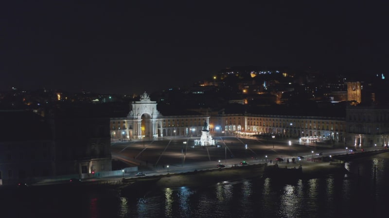 Aerial dolly in night view of Praca do Comercio square and Arco da Rua Augusta monument with bright lights  in Lisbon, Portugal