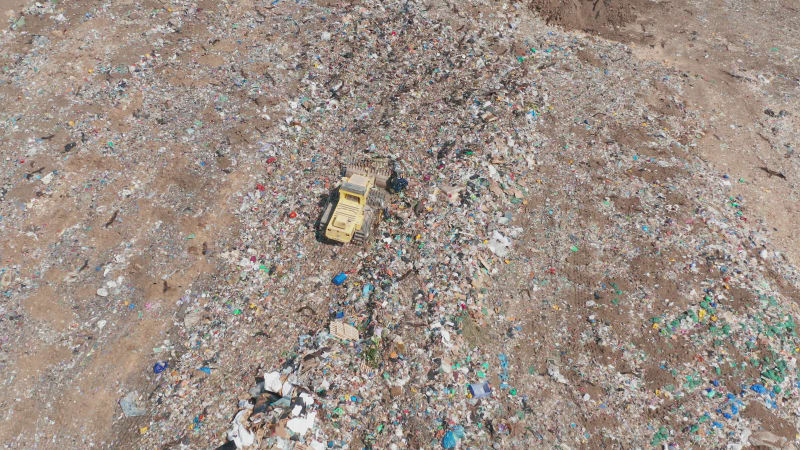 Aerial view of a Yellow Landfill compactor at Municipal Solid waste compound.