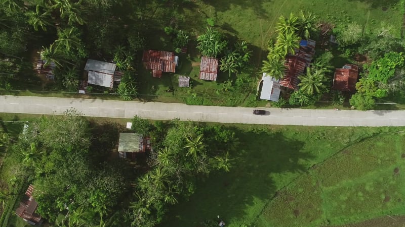 Aerial view following car on road. Chocolate Hills Complex.