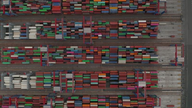 Overhead top down aerial view of automated cranes moving colorful cargo containers in Hamburg port