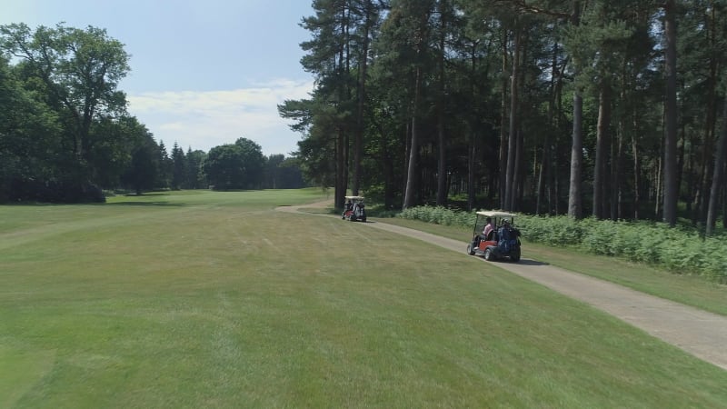 Golfers Driving Buggies Down the Fairway of a Golf Course