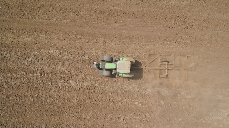 Aerial view of a tractor ploughing an empty field, Kibbutz saar, Israel.