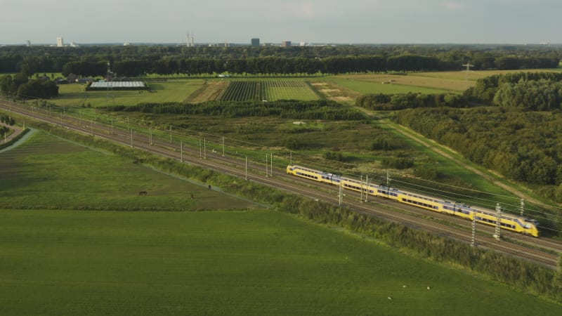 Tracking shot train speeding through Dutch countryside