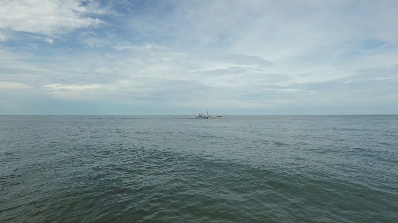 Aerial view of small fishing boat navigating on calm water, Ko Chang.